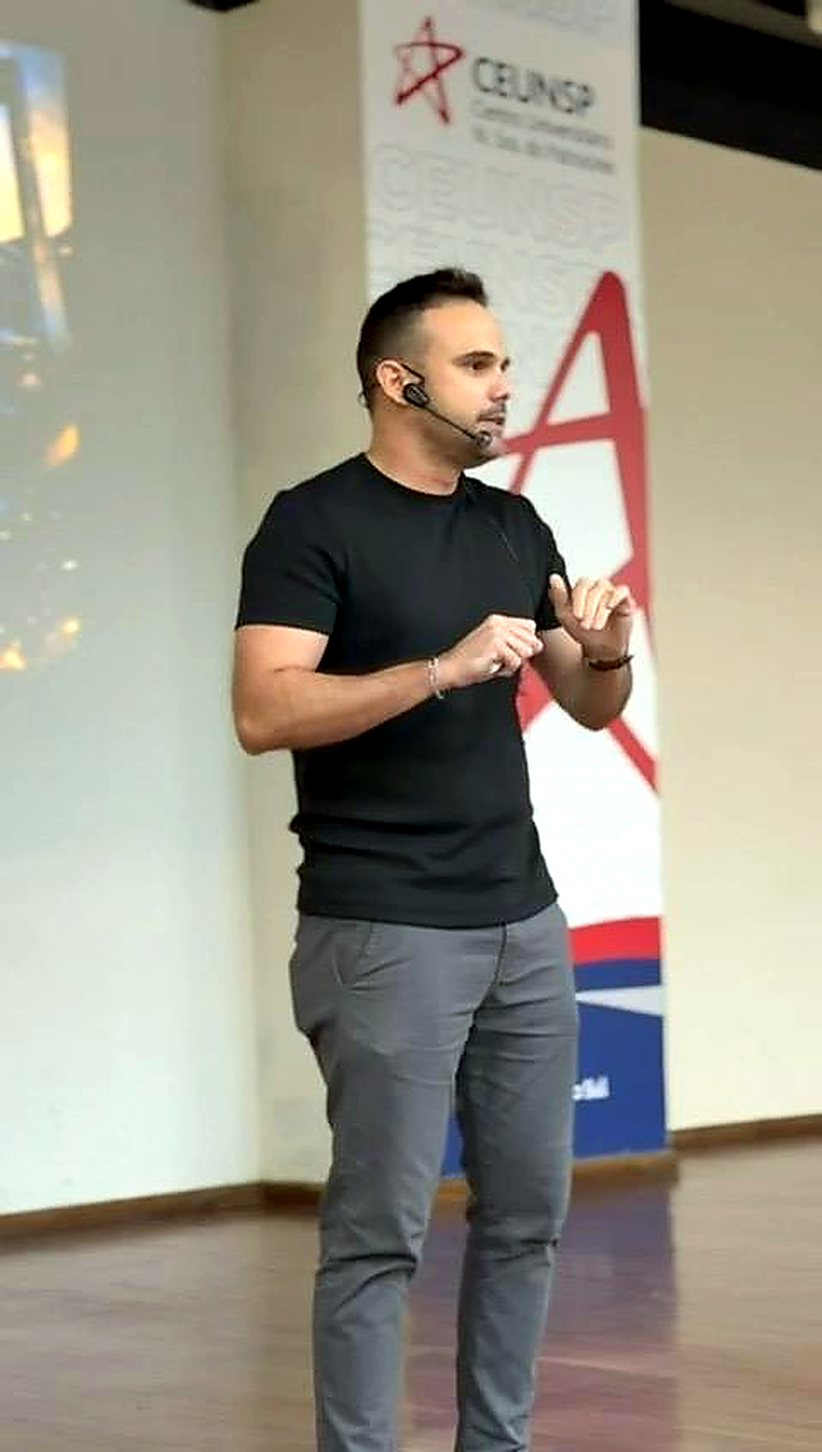 Renan Rodrigues em ambiente institucional, conduzindo apresentação